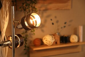 A modern lamp with a spherical shade, a metal stand, and decorative items on a shelf in the background.