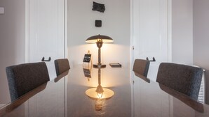 A conference room with a glass table, two upholstered chairs, a standing lamp, and a welcome sign. - Bed and Breakfast The Rose (Haarlem)