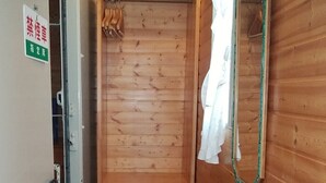 A wooden interior with a shower area, a mirror, and a tiled floor. - Country House Morning Salad (Fujikawaguchiko)