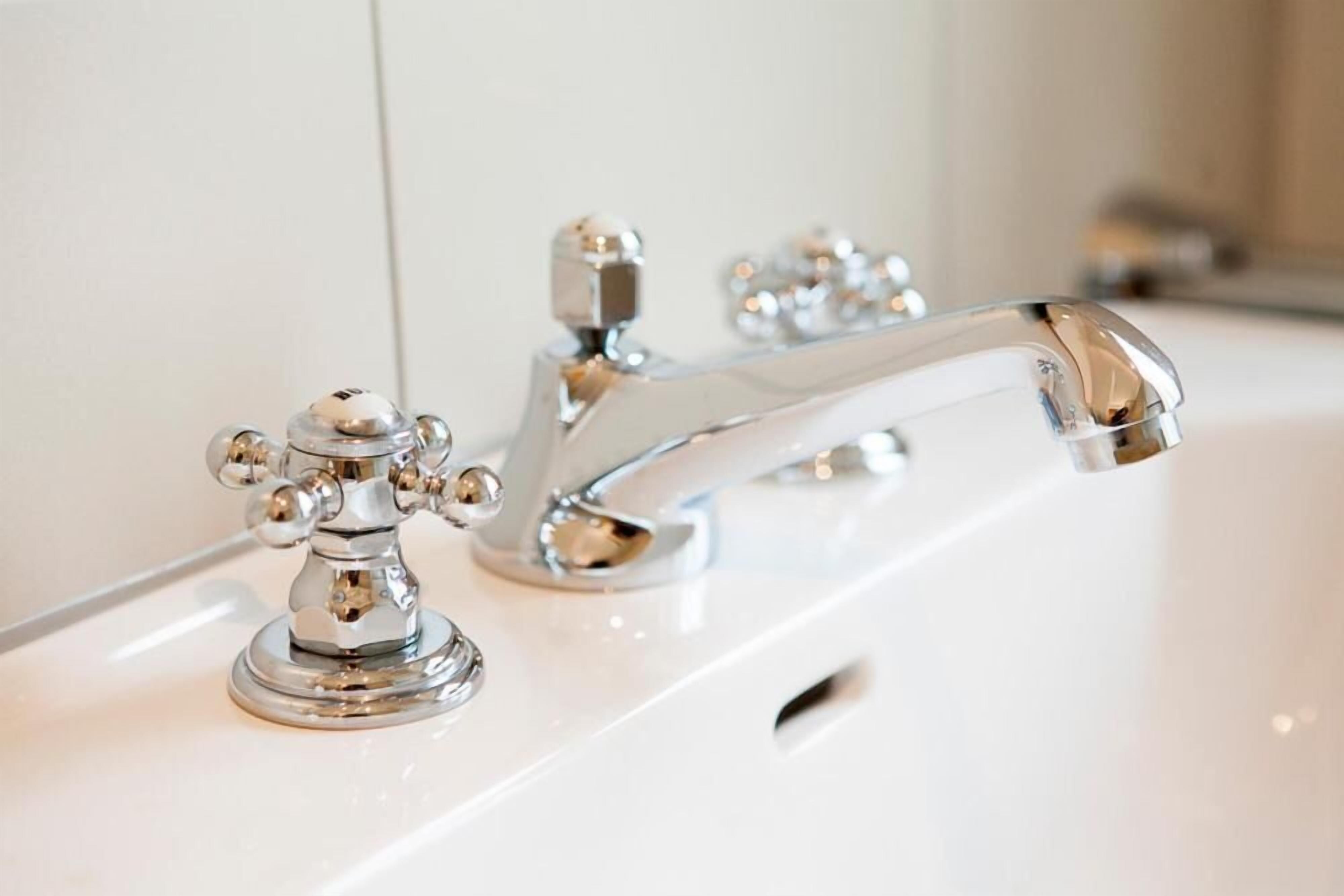 A chrome faucet with a single handle and a separate hot and cold control.