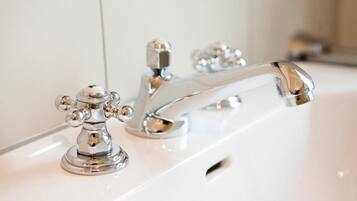 A chrome faucet with a single handle and a separate hot and cold control.