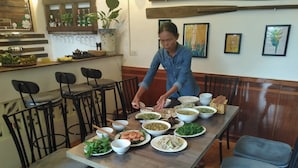 A dining area with a long table set for a meal, surrounded by chairs. - Tam Coc Sweet Home (Nam Hoa Lu)