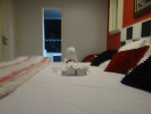 A hotel room with a bed, pillows, and a window. - Casa Temporada Jardim Iguaçu (Foz do Iguaçu)
