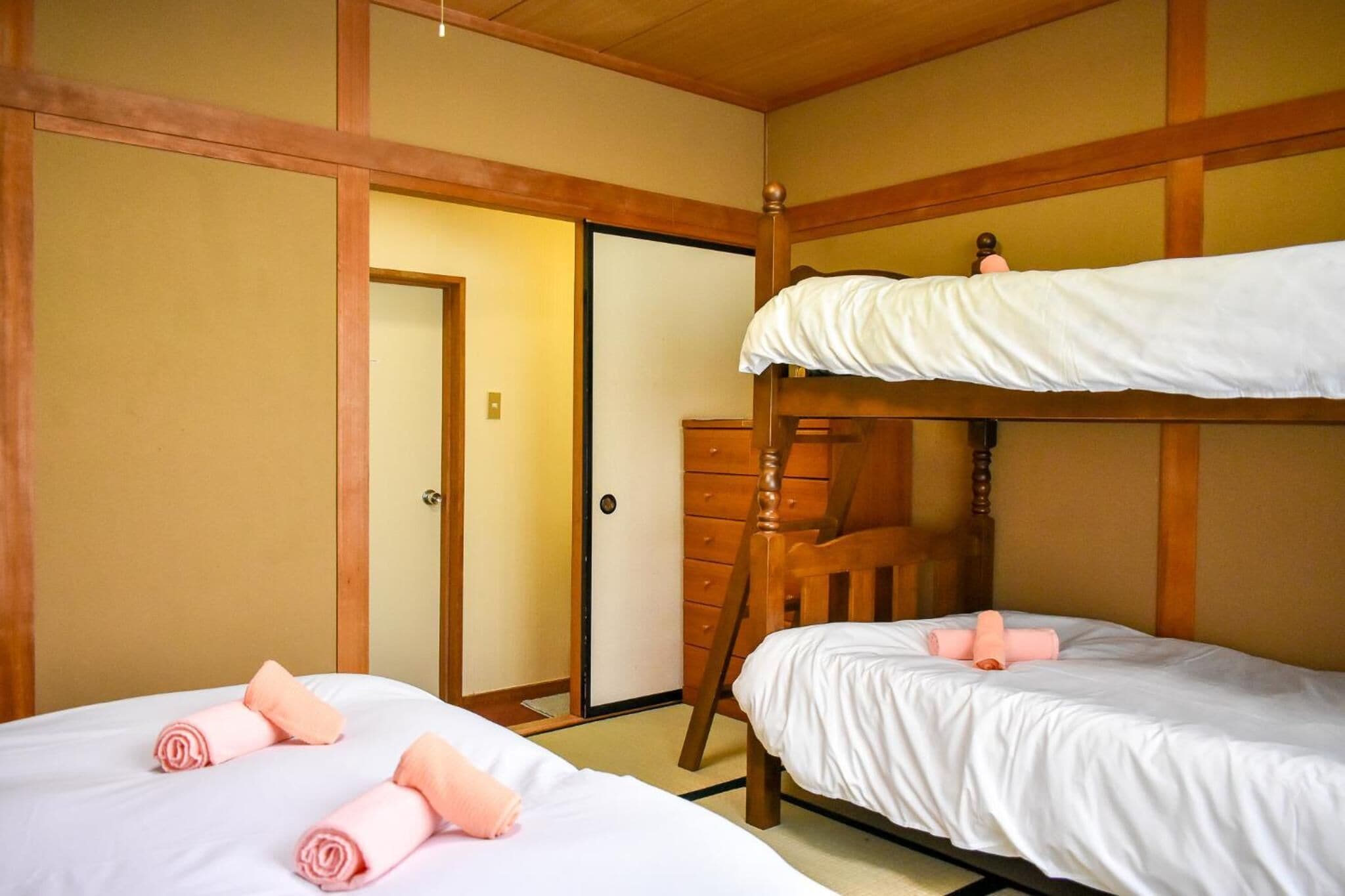 A hotel room with two beds, wooden headboards, and a wardrobe.