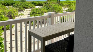Un balcon avec vue sur une plage et des palmiers.