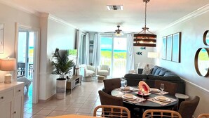 Un coin repas avec une table ronde pour deux personnes, un canapé et un balcon avec vue.
