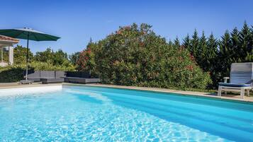 Alberca al aire libre y camastros