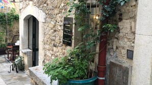 Un edificio de piedra con un cartel que indica una galería de arte y un restaurante llamado Le Roché.