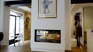 Un interior moderno con chimenea, obras de arte enmarcadas y una pared de piedra.