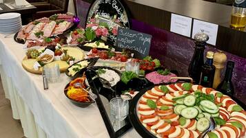 Taula de buffet amb diferents plats i un cartell que diu 'Butter, Paprika, Heringssalat'.