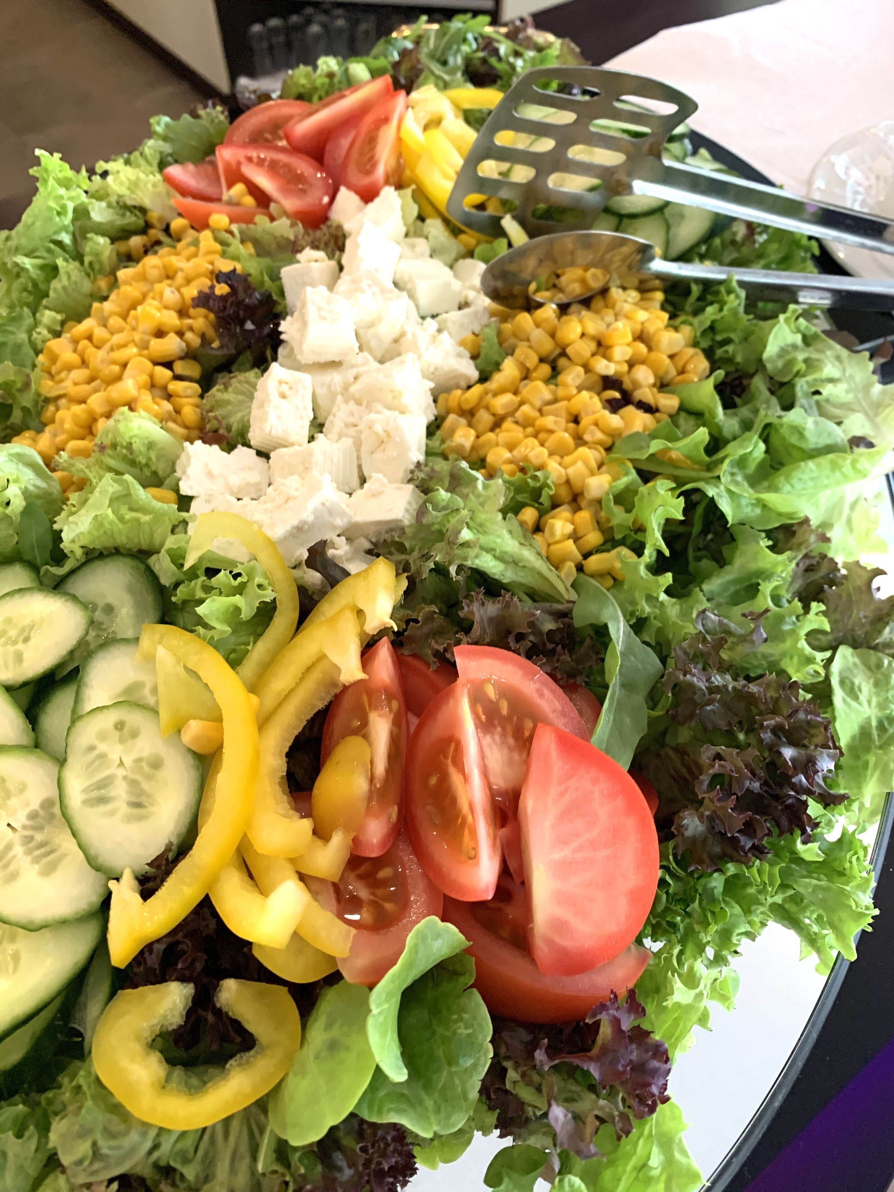 Une salade composée de différents légumes et une fourchette.