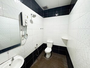 A bathroom with white tiled walls, a black-tiled floor, a toilet, a sink, and a shower with a handheld showerhead.