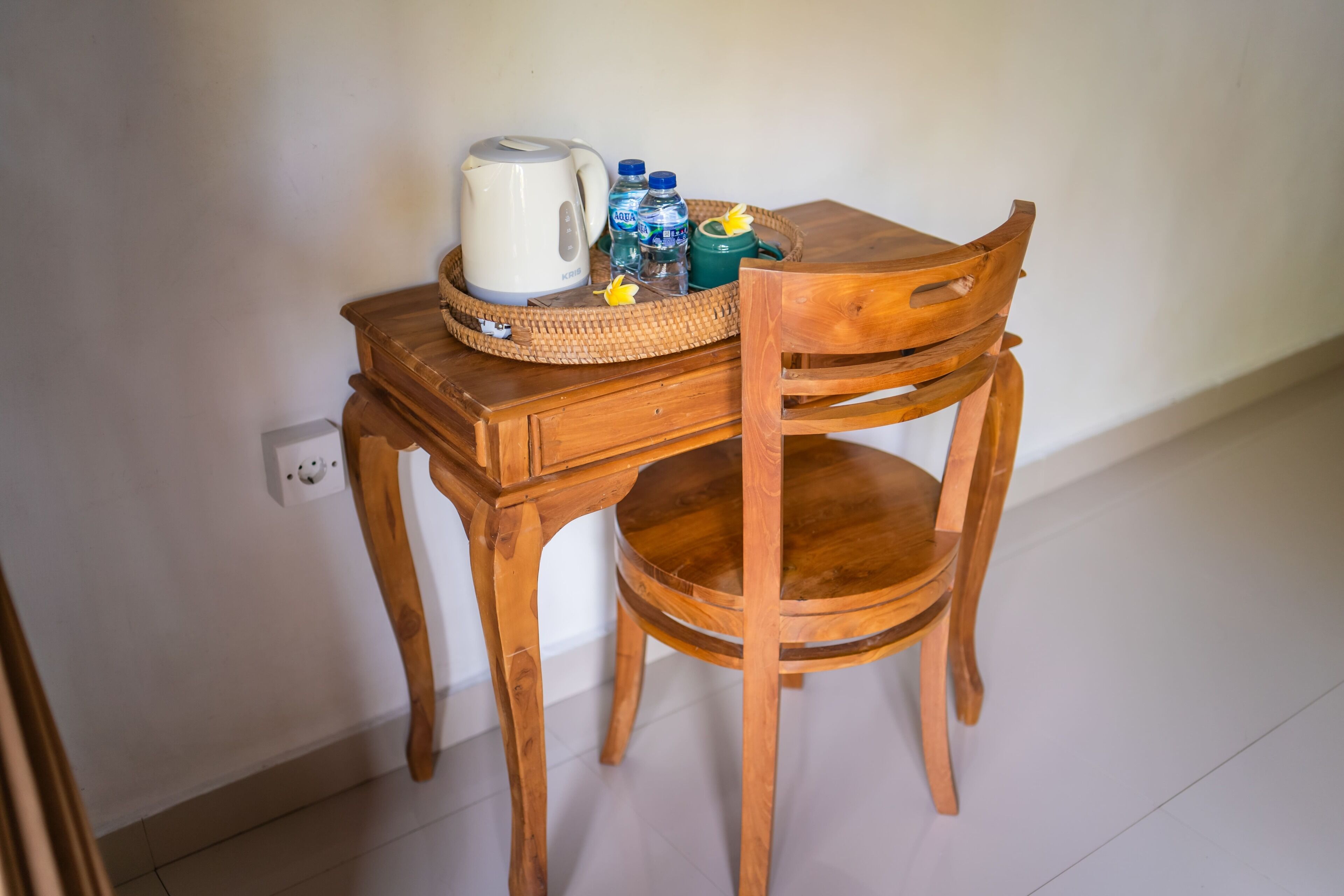 A wooden table with a kettle, water bottles, and a green container.