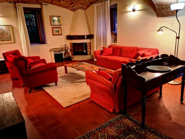 A living room with red furniture, a fireplace, and a patterned rug. - "CASA DEL CANTA" FREE WI-FI, FREE PARKING. (borgomale)