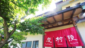 A building with a red banner displaying "Yoshimura house hotel VI" and a tree in the foreground. - Yoshimura House Hotel 6 (Fujikawaguchiko)