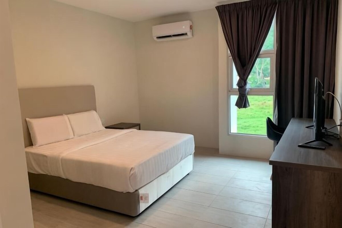 Un dormitorio con cama, escritorio, aire acondicionado y ventana con cortinas.