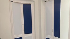 A bathroom with a white sink, a mirror, and two doors with blue panels. - The Sassy House (Langkawi)