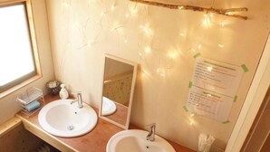 Une salle de bain avec deux lavabos, un miroir et des guirlandes lumineuses.