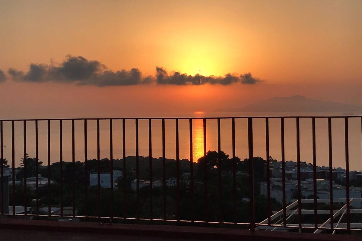 A sunset over a body of water with a cityscape in the background.