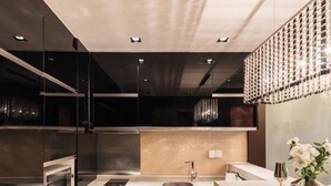 A modern kitchen with a central island, stainless steel appliances, and a decorative light fixture above the sink. - Guangzhou Y&W Service Apartment (Guangzhou)