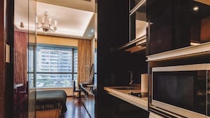 A modern kitchen with a built-in washer and dryer, a dining area with a view, and a large window. - Guangzhou Y&W Service Apartment (Guangzhou)
