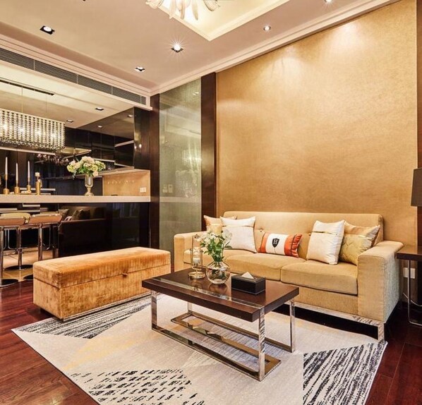 A modern living room with a sofa, ottoman, and coffee table.