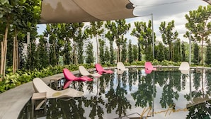 Uma área de piscina com espreguiçadeiras e um toldo.