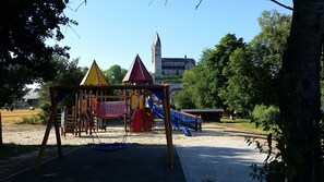 A playground with a swing set, a slide, and a climbing structure.