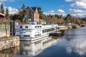 Un bateau fluvial était amarré à un quai, avec un bâtiment visible en arrière-plan.