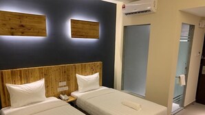 A hotel room with two beds, wooden headboards, and a small bedside table with a phone. - TLJ Hotel (Pelabuhan Klang)