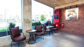 A café with brick walls, large windows, and a fire extinguisher. - TLJ Hotel (Pelabuhan Klang)