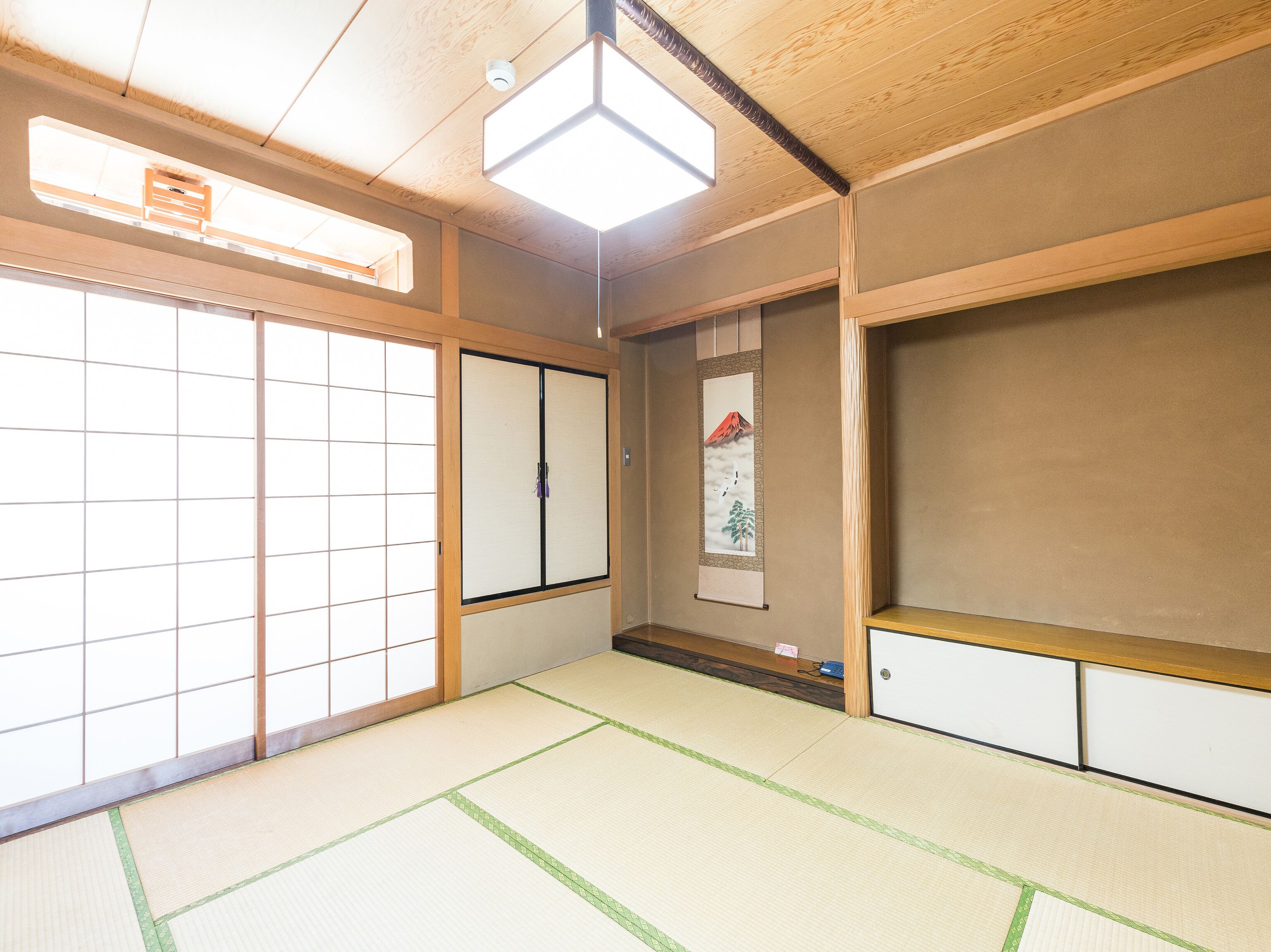 Una habitación japonesa tradicional con suelo de tatami, puertas correderas y un panel shoji.