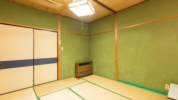 Una habitación con suelo de tatami, un calentador de estilo japonés tradicional y una puerta corredera.