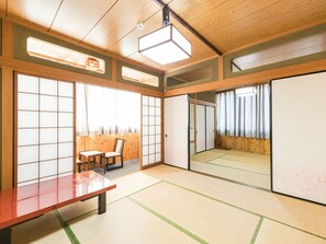 A traditional Japanese room with tatami flooring, a low wooden table, sliding doors, and a large mirror. - Tabist Samotokan Owariasahi (Owariasahi)