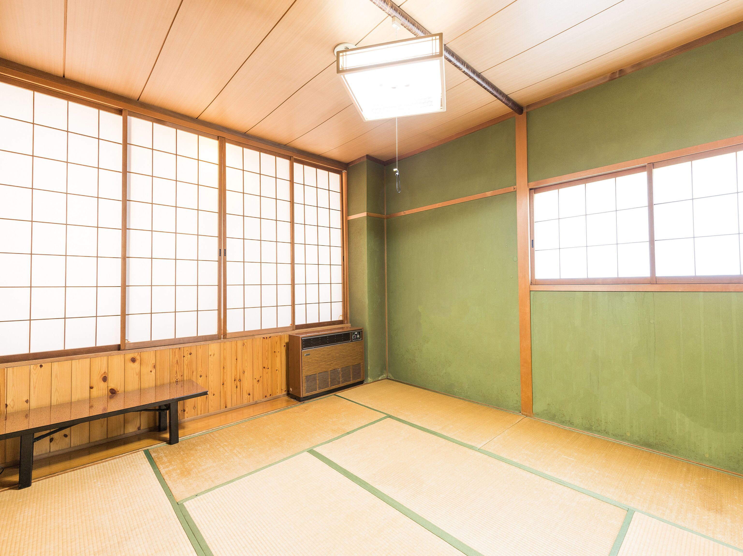 A traditional Japanese room with tatami flooring, shoji screens, and a wooden bench.