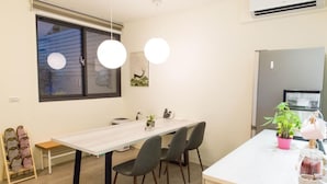 A modern kitchen with a white countertop, a built-in oven, and a small island with a plant and a coffee maker.