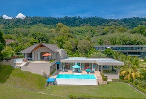 Una piscina al aire libre, sombrillas, sillones reclinables de piscina