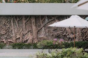 A wall with a detailed relief sculpture of trees and wildlife.
