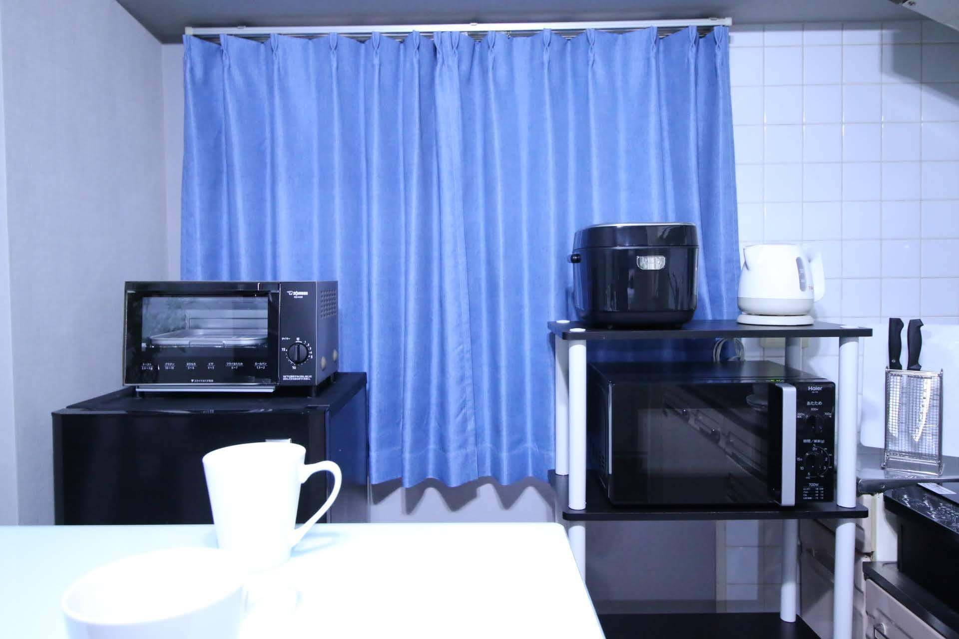 A compact kitchen with a microwave, toaster, and coffee maker on a countertop.