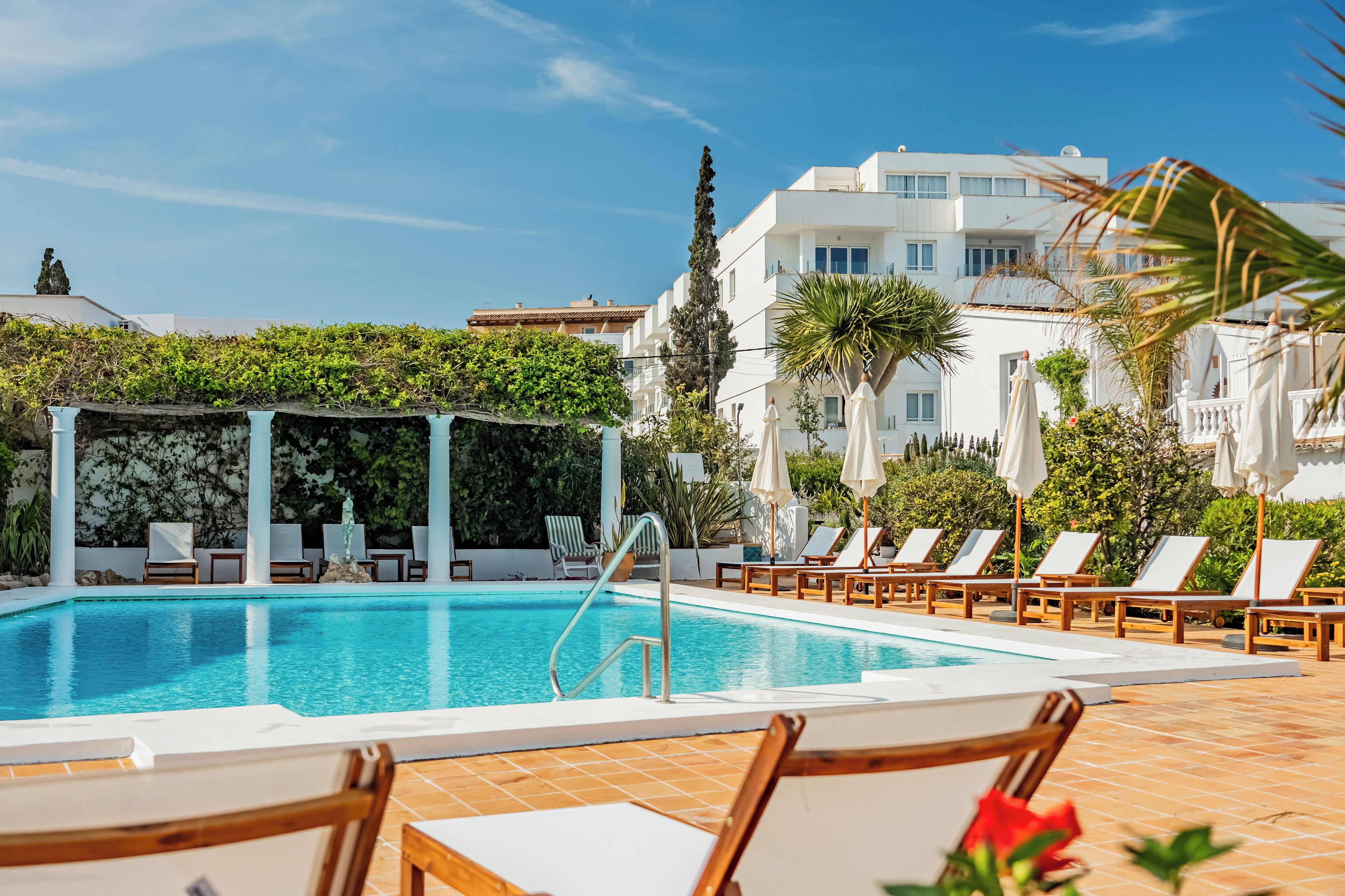 Una piscina al aire libre, una piscina climatizada, sombrillas