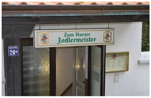 A building entrance with a sign reading "Zum Harzer Jodlermeister" and a sign indicating room number 26a. - Zum Harzer Jodlermeister (Thale)