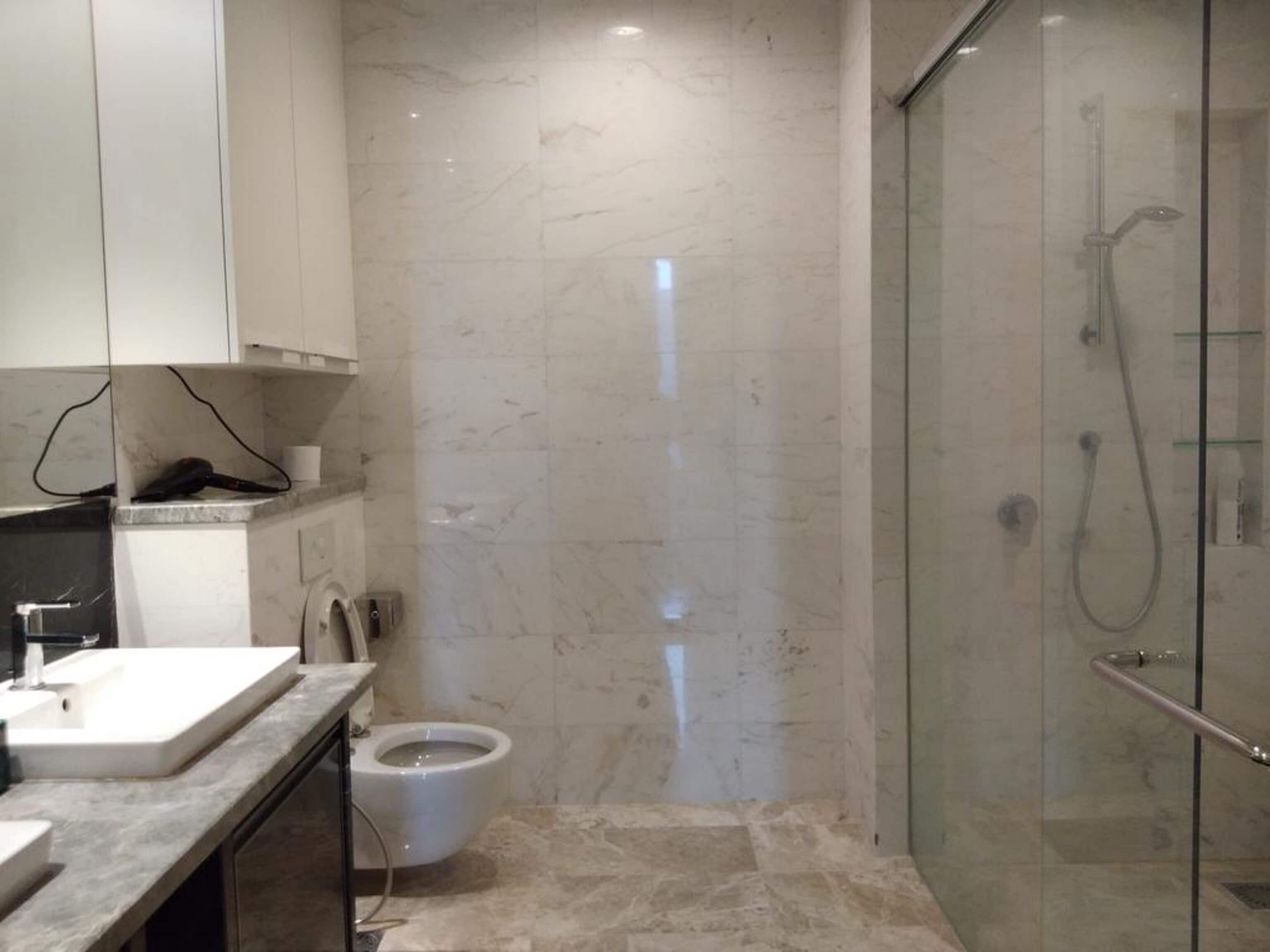 Une salle de bain moderne avec une douche à parois de verre, des toilettes et un lavabo.