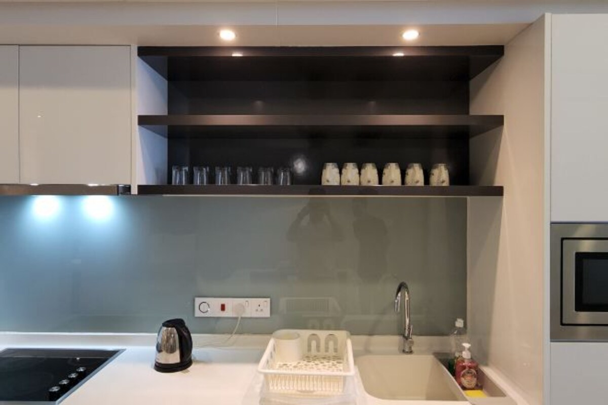 Een moderne keuken met een inbouwfornuis, waterkoker, spoelbak en een aanrecht met een afwasschaal.