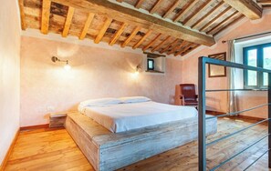 A bedroom with a wooden bed, a chair, a window, and a wooden ceiling. - Comfortable Villa con Piscina - La Torre for up to 6 guests (Perugia)