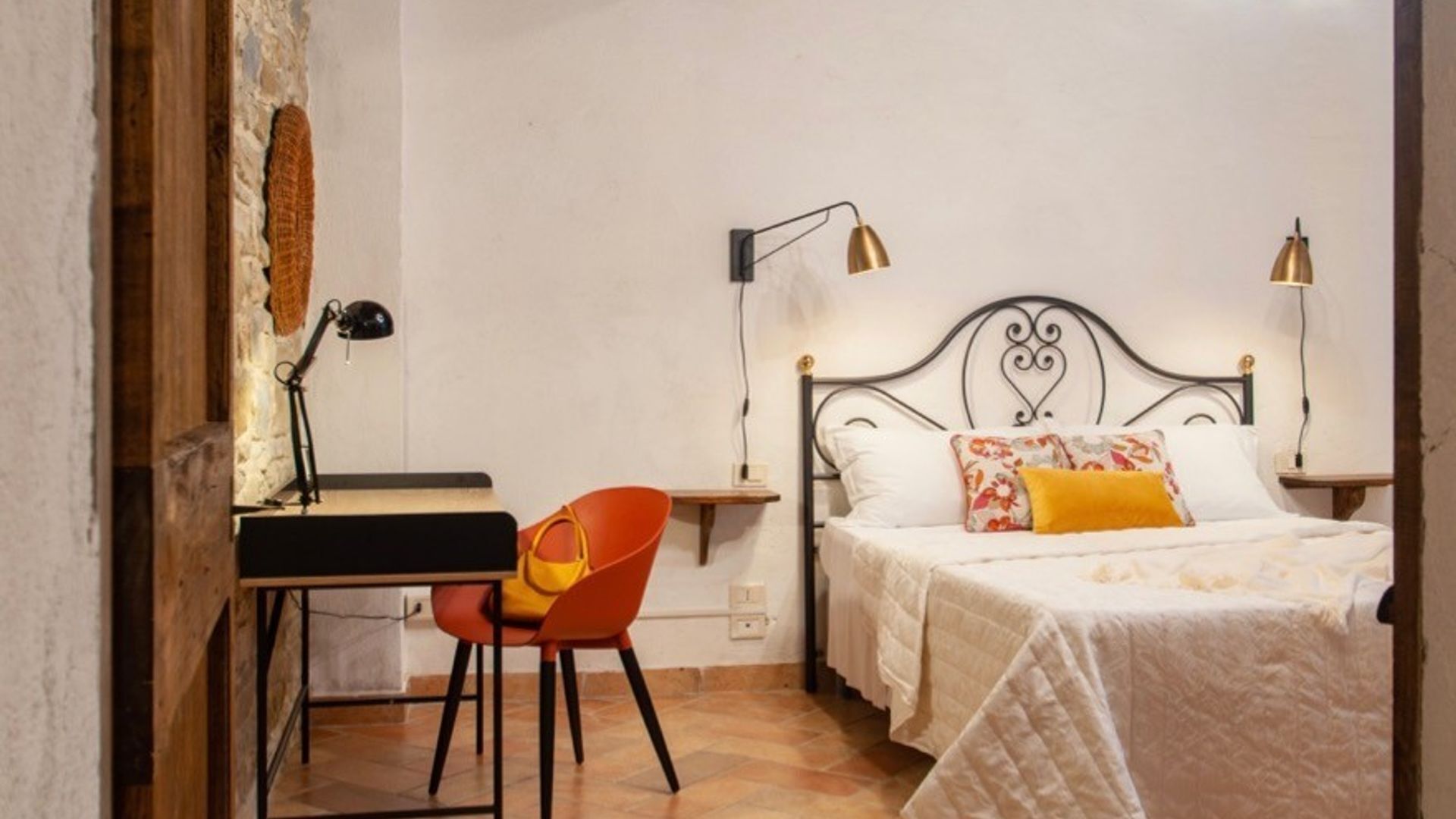 Ein Schlafzimmer mit einem Bett, einem Schreibtisch, einem Stuhl und zwei Nachttischlampen.