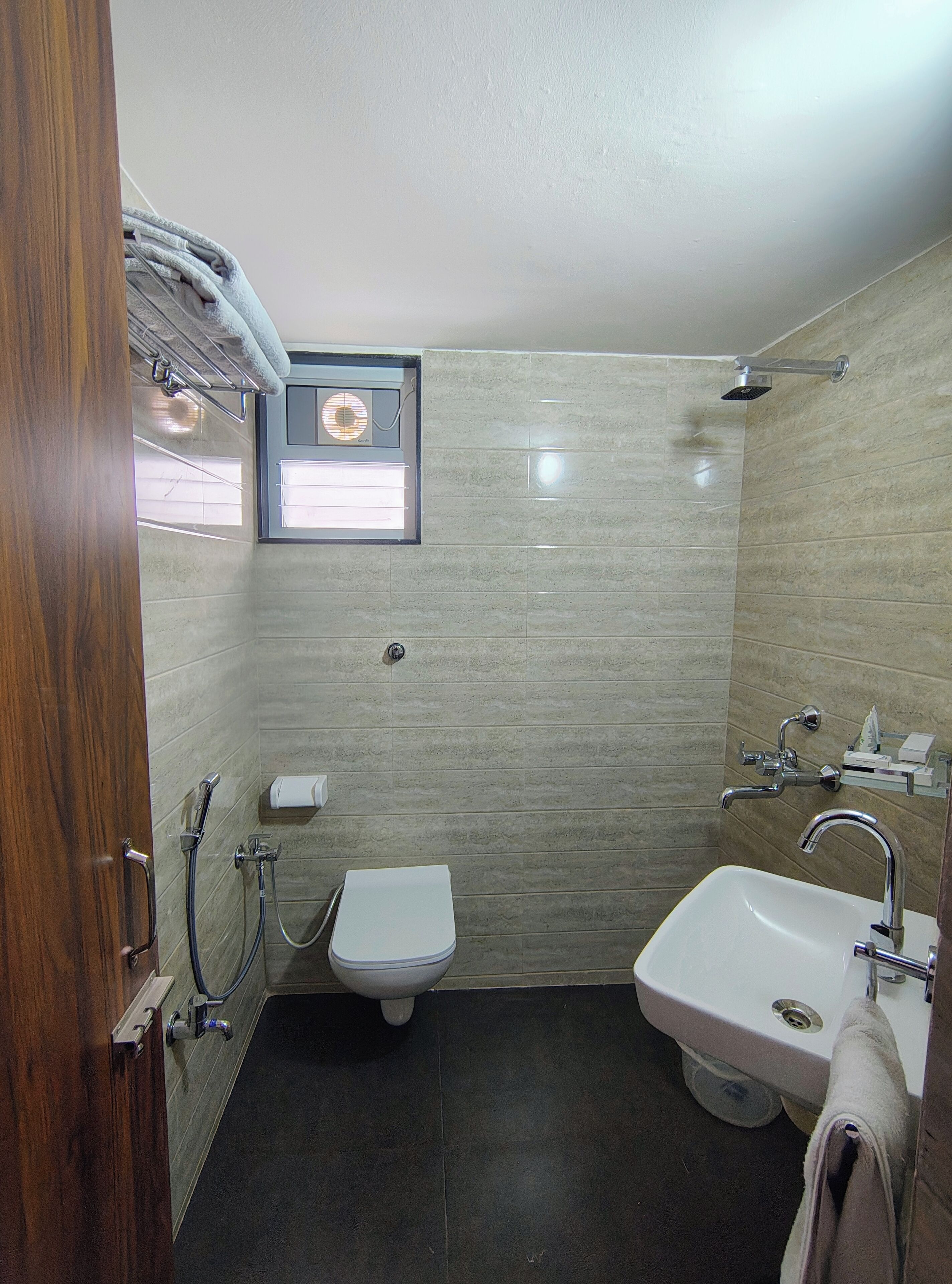 A compact bathroom with a toilet, sink, and shower.