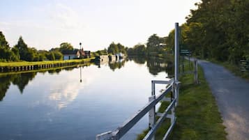 Een rustige gracht met een houten hek en een pad ernaast.
