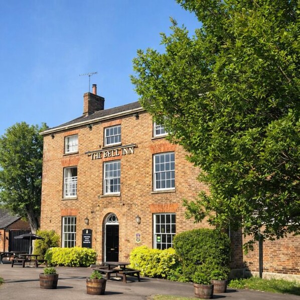 A brick building with a sign reading "The Bell Inn".