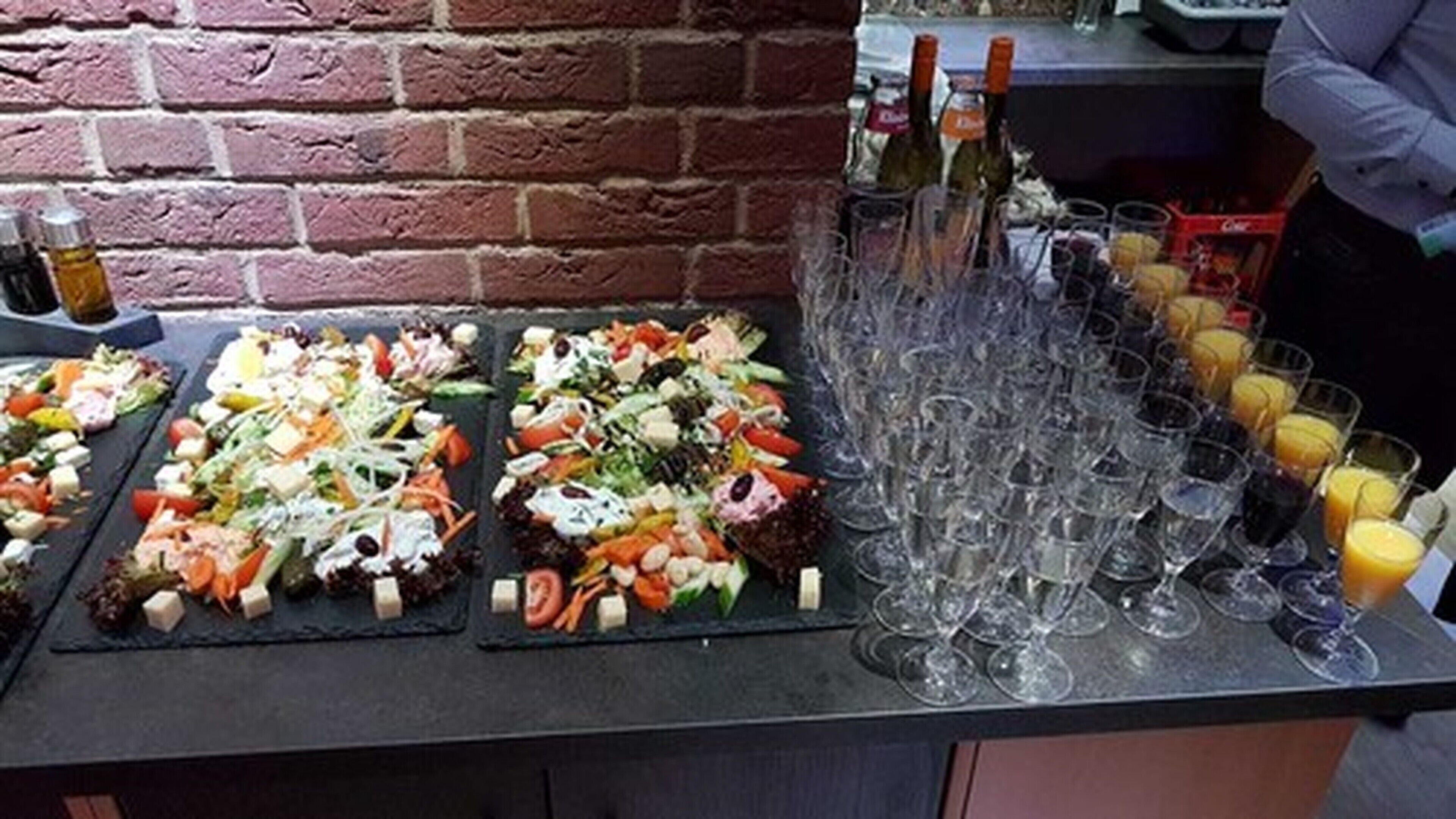 A buffet table with various dishes and a selection of drinks.