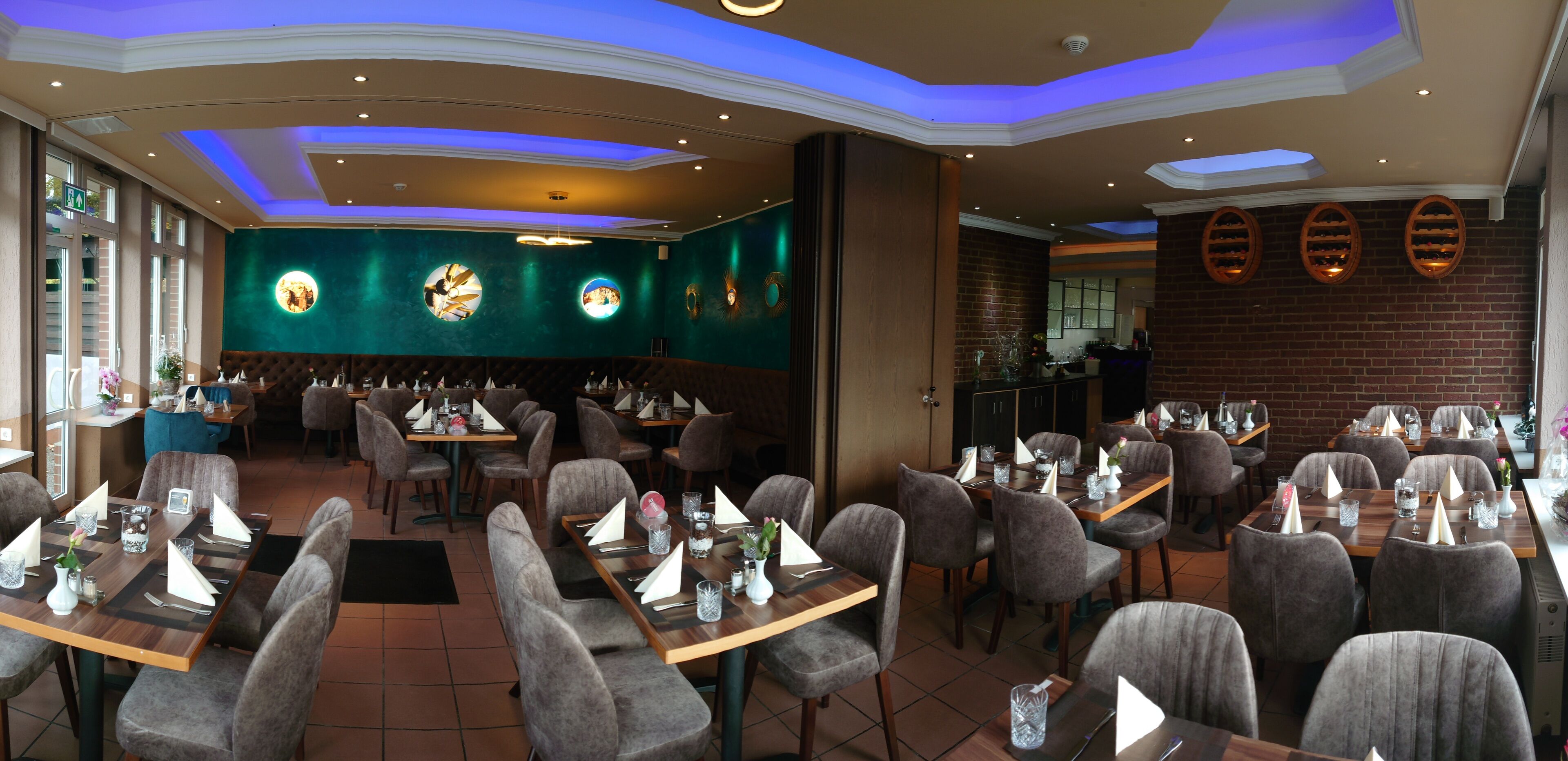 Ein Restaurant mit mehreren Tischen, Stühlen und einer Bar.